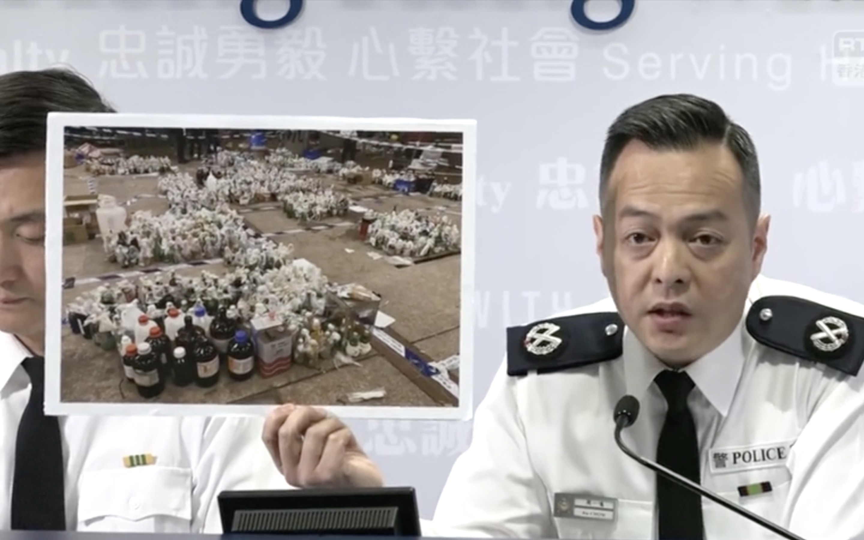 Assistant commissioner of police operations, Chow Yat-ming holds up a photo of molotov cocktails seized from the Hong Kong Polytechnic University. Screengrab via Facebook.