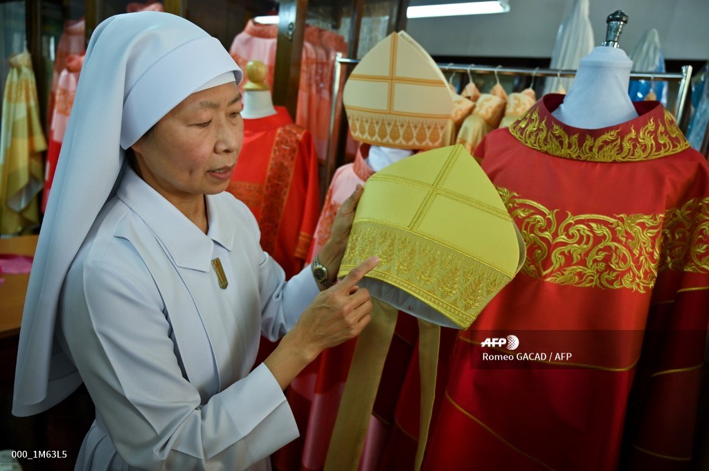 Sister Saengpradab holds embroidered headwear beside the silk robe, at right, for Pope Francis on Monday at the Praharuthai Convent in Bangkok. Photo: Romeo GACAD / AFP