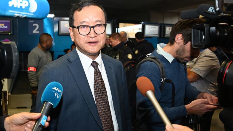 Sam Rainsy speaks to the press at Charles de Gaulle airport in Paris on Thursday after his failed attempt to board a plane to the Thai capital Bangkok. DOMINIQUE FAGET/AFP 