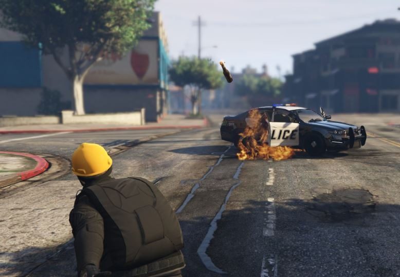 A player hurls a molotov cocktail at a police car in “Grand Theft Auto V.” Photo via LIHKG.