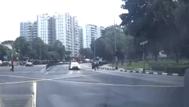 The moment a rider was kicked off his scooter at high speed onto the road Tuesday on Singapore’s Bedok Reservoir Road. Original images: Bombocey/Instagram
