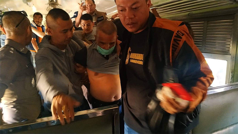 Somkid Pumpuang is dragged off a train Wednesday morning in Pak Chong. Photo: Royal Thai Police