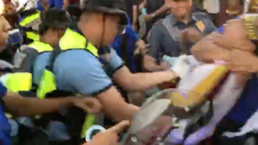 Jun Veneracion’s shot of a devotee being manhandled by cops was allegedly ordered deleted by a police general. Photo: Shot from Veneracion