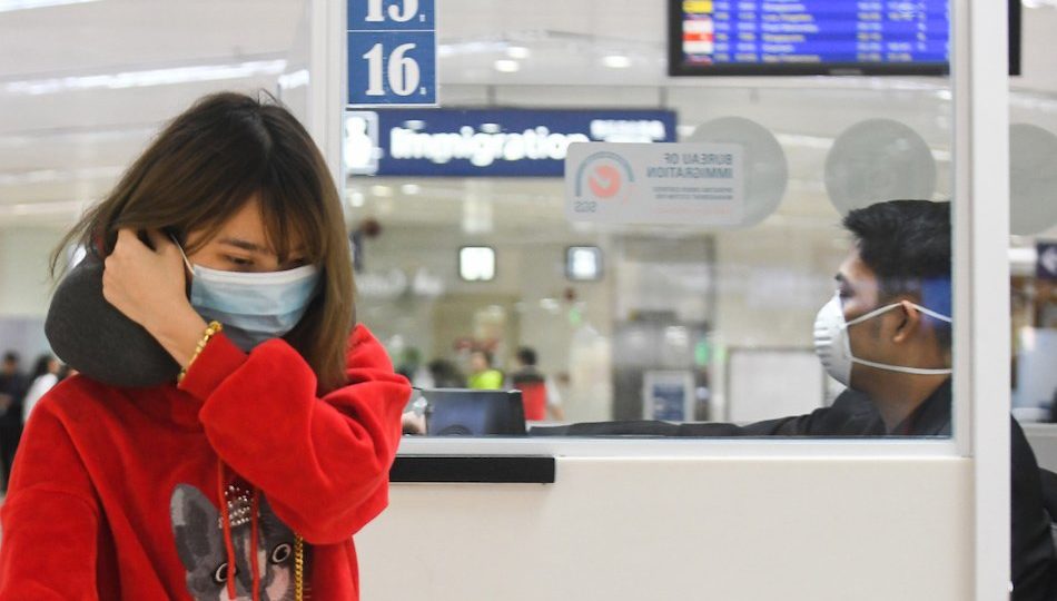 A passenger and an immigration officer at the Ninoy Aquino International Airport have worn masks in light of the spread of the novel coronavirus. <i></noscript>Photo: Mark Demayo/ABS-CBN News</i>