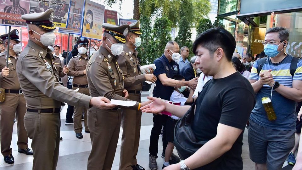Police hand out masks for tourists in front of Siam Paragon, a top tourist destination in Bangkok. Photo: OneSiam / FB