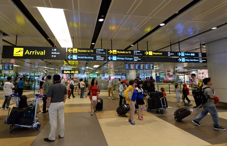 Travelers arrive at Changi Airport in a file photo. Photo: Roslan Rahman/AFP
