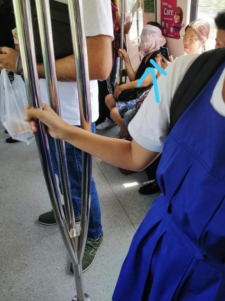 Woman with unusual headgear onboard Singapore train. Photo: Leely Latif via Complaint Singapore/Facebook