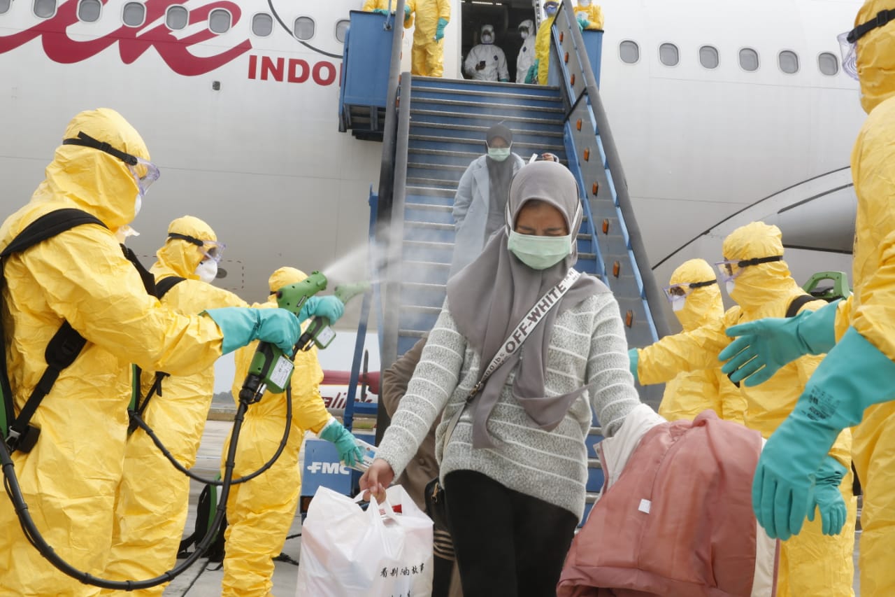 Indonesian nationals evacuated from China being sprayed with disinfectant as they leave the aircraft on Feb. 2, 2020. Photo: Indonesia Foreign Ministry