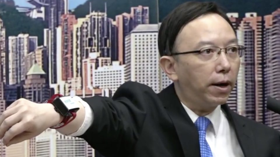 The government’s chief information officer Victor Lam shows off a new electronic tag that will be given to people under home quarantine as the Wuhan coronavirus fears continue to grip the city. Screengrab via Facebook video/RTHK.