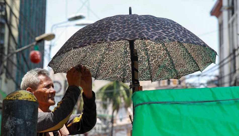 A pedicab driver fixes his umbrella under the scorching heat. <i></noscript>Photo: Jonathan Cellona, ABS-CBN News</i>