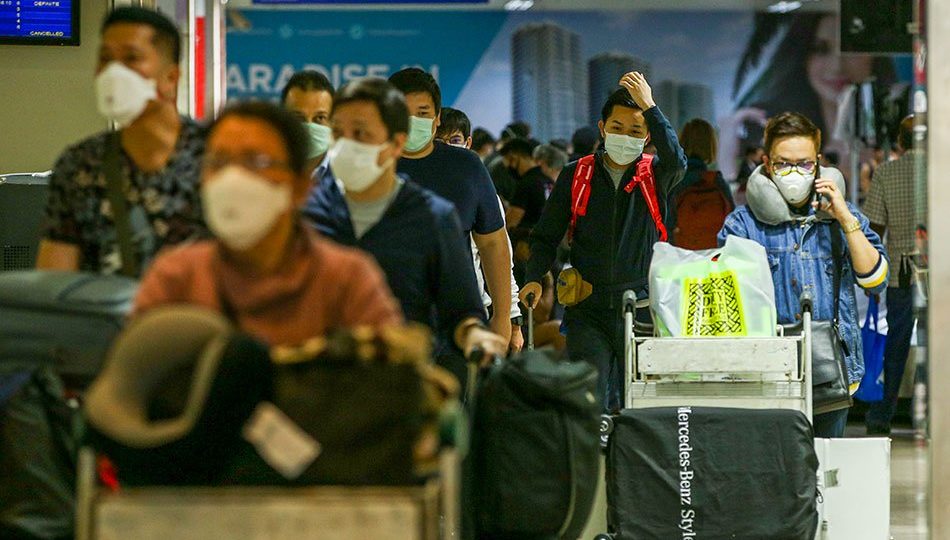 Travelers wearing face masks at the Ninoy Aquino International Airport Terminal 1 <i></noscript>Photo: Jonathan Cellona / ABS-CBN News</i>