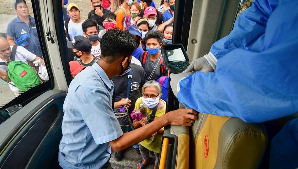 A Quezon City government bus picks up passengers on Tuesday amid mass transport suspension brought about by the enhanced community quarantine. <I></noscript>Photo: Mark Demayo / ABS-CBN News</i>