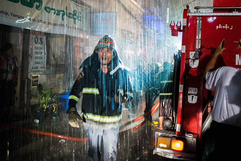 Yangon firefighters at the scene of Thursday night’s blaze on 37th Street in Kyauktada Township. Photo: Ludivine Paques 