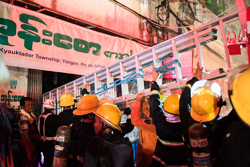 Yangon firefighters at the scene of Thursday night's blaze on 37th Street in Kyauktada Township. Photo: Ludivine Paques 