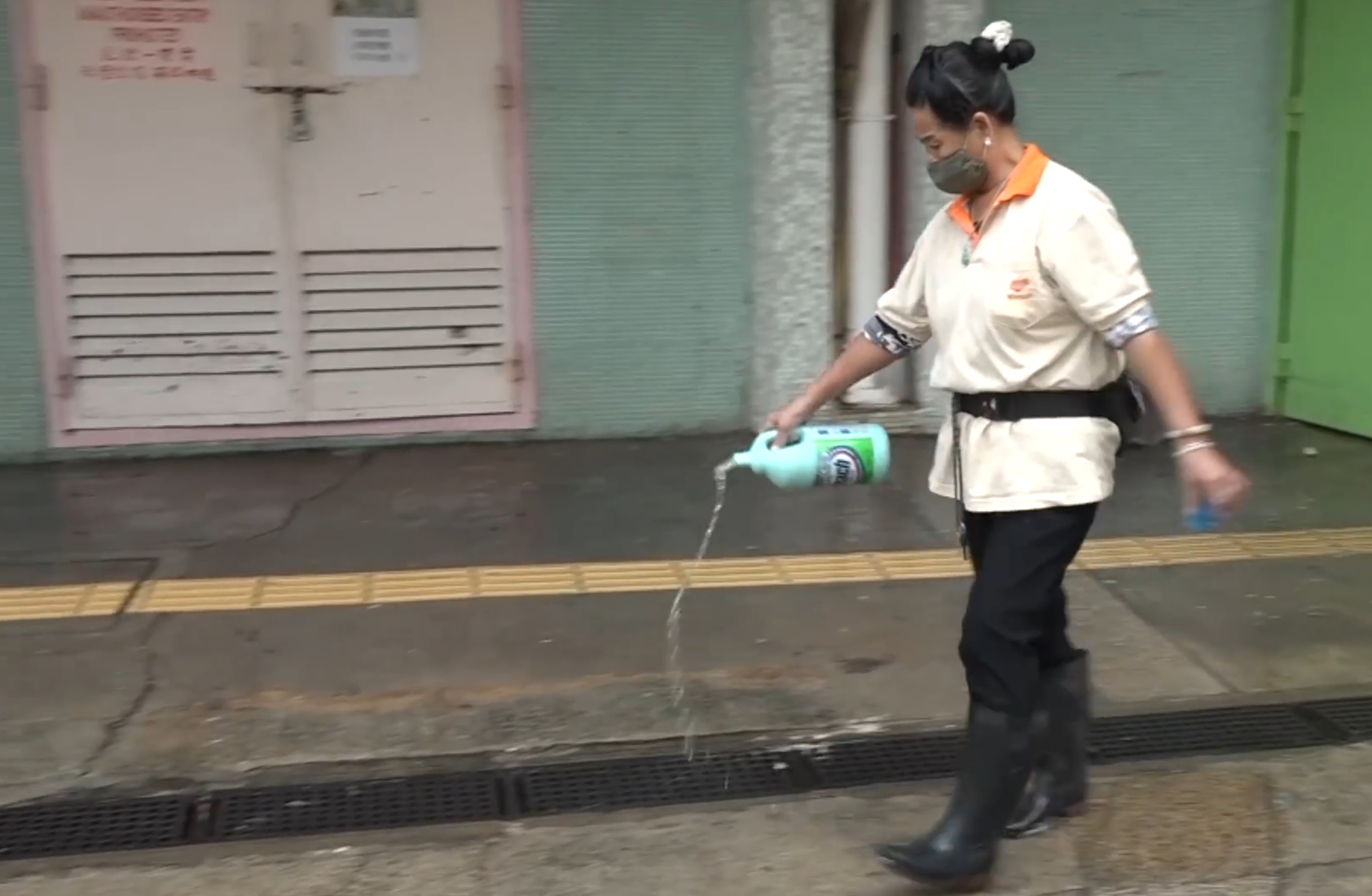 A worker disinfects the entrance of a Tai Po housing block after it was partially evacuated over fears of coronavirus transmissions in the building. Screengrab via Facebook/RTHK.
