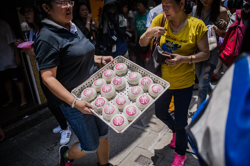 A bakery worker walks with a tray of freshly made “lucky” white buns in May 2015. Photo (for illustration): Kevin Dharmawan for Coconuts Media