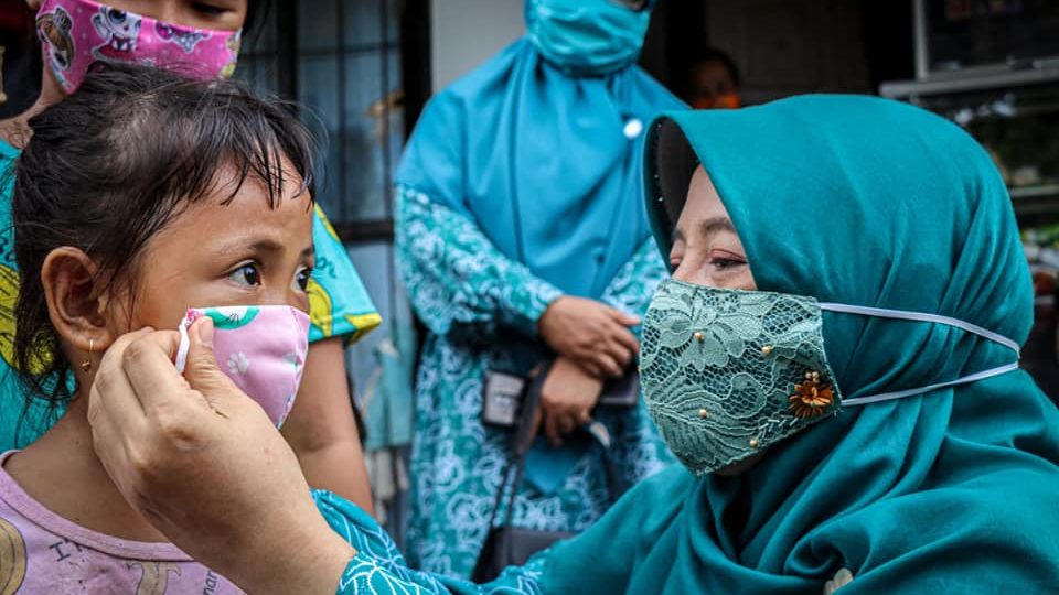 File photo of an official from NTB putting on a face mask for a girl. Photo: NTB provincial government  