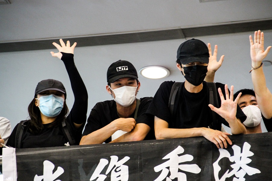 Protesters in Harbour City perform the 'Five demands, not one less' gesture while displaying a 'Liberate Hong Kong, revolution of our times' flag. Photo: Tommy Walker