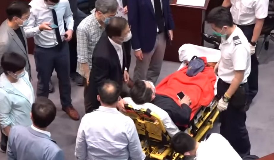 Democratic lawmaker Andrew Wan was taken out of LegCo on a stretcher after injuring his back. Screengrab: Apple Daily via Youtube