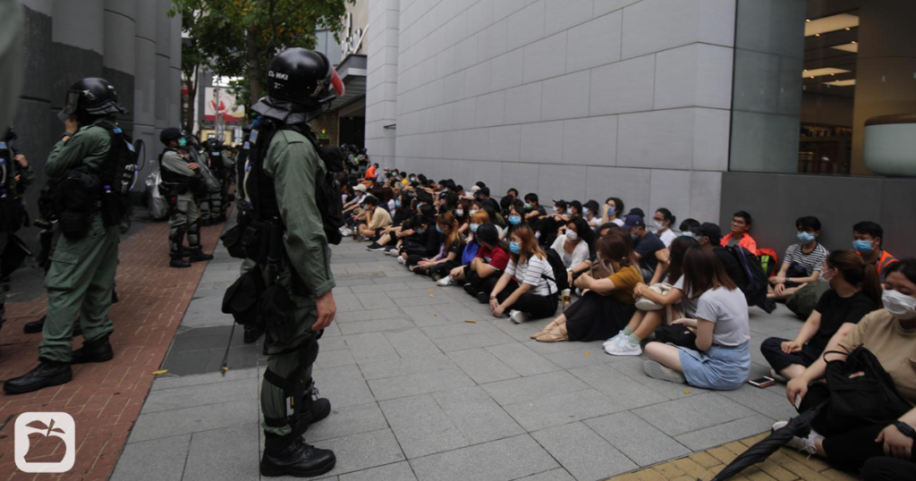 Protesters detained by police sit outside Hysan Place in Causeway Bay on May 27, 2020.