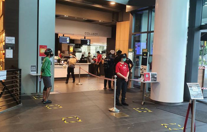 An employee stands by to check customers’ temperatures at the entrance of the outlet at Raffles City shopping mall. Photo: Singapore Atrium Sale/Facebook