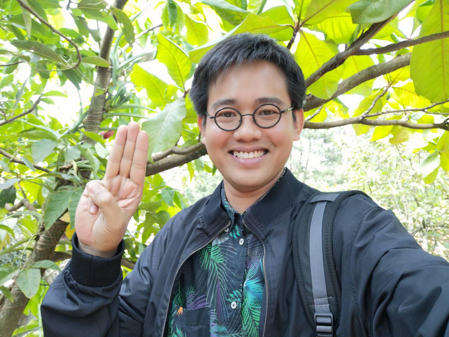 A file photo of Wanchalerm Satsaksit raising three fingers as a symbol against dictatorship. 
