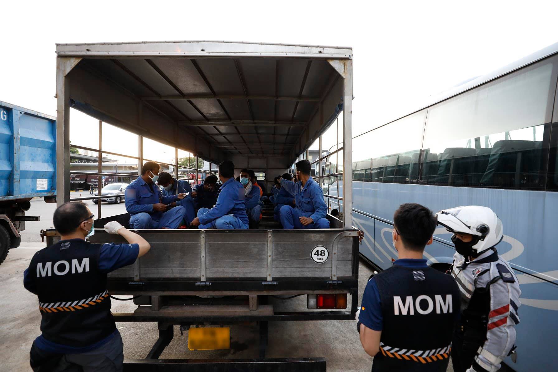 Ministry of Manpower officers question migrant workers in the back of a truck in an undated photo. Photo: Ministry of Manpower/Facebook