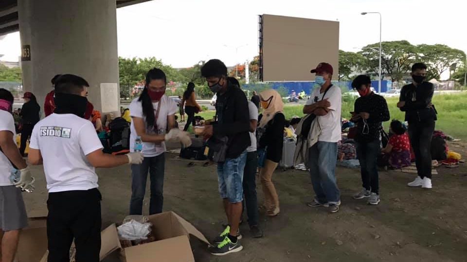 Volunteers give food to stranded passengers at NAIA. Photo: Monique Ramirez/FB