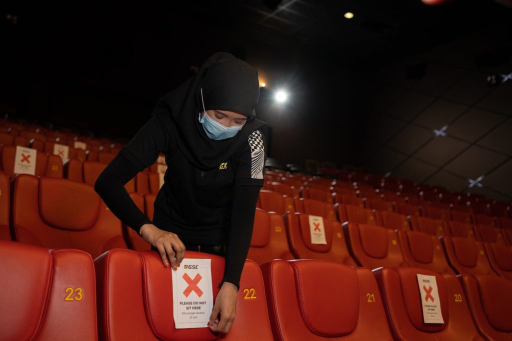 Cinema staff placing social distancing notices on seats. Photo: GSCinemas /Facebook