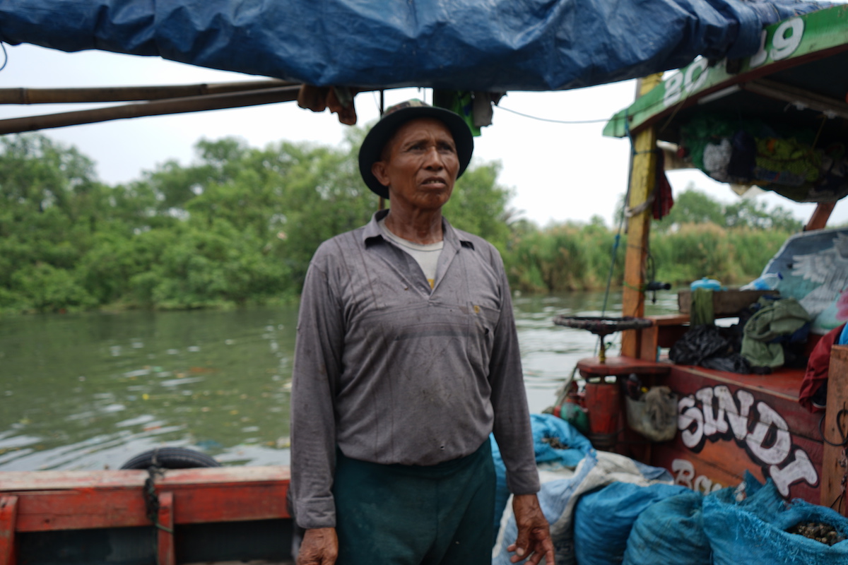 Pasiban, 60, is a clam picker in Muara Angke, North Jakarta. Photo: Adi Renaldi