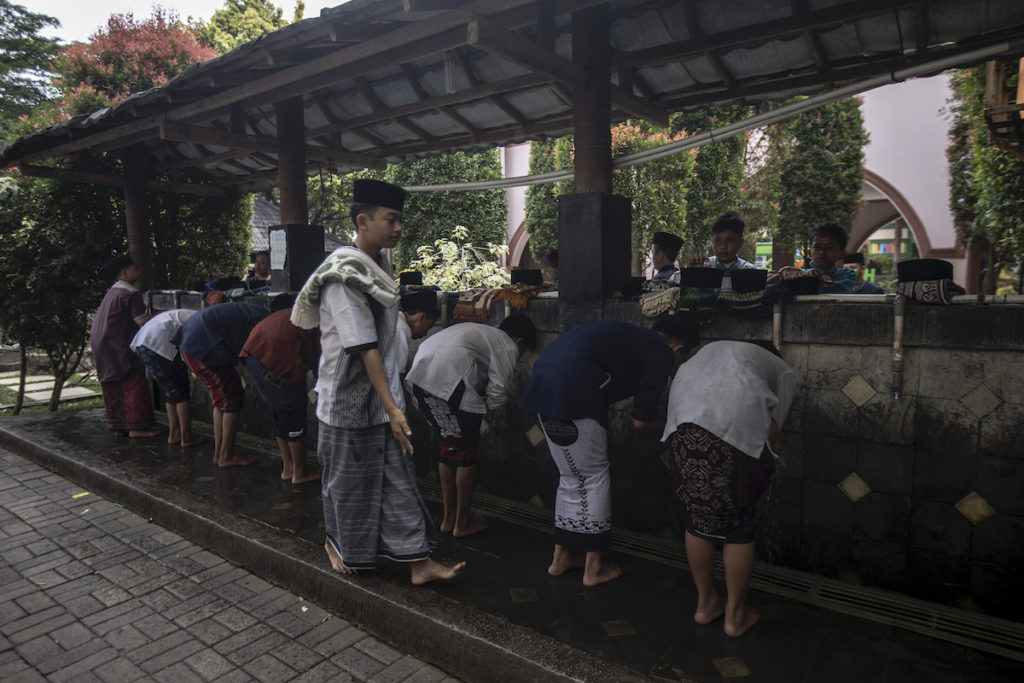 Students purify themselves with clean water at an ablution station before prayer. Photo: Coconuts Media/Agung