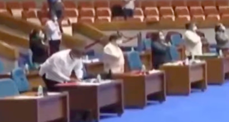 Remulla taking notes while the national anthem plays at the start of the House Committee hearing on ABS-CBN franchise. <i></noscript>Video grab via YouTube</i>