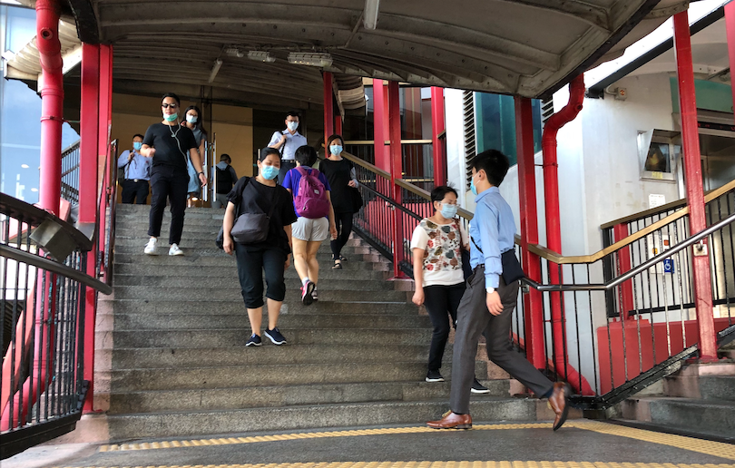 Commuters walk along a bridge in Sheung Wan on July 14, 2020.