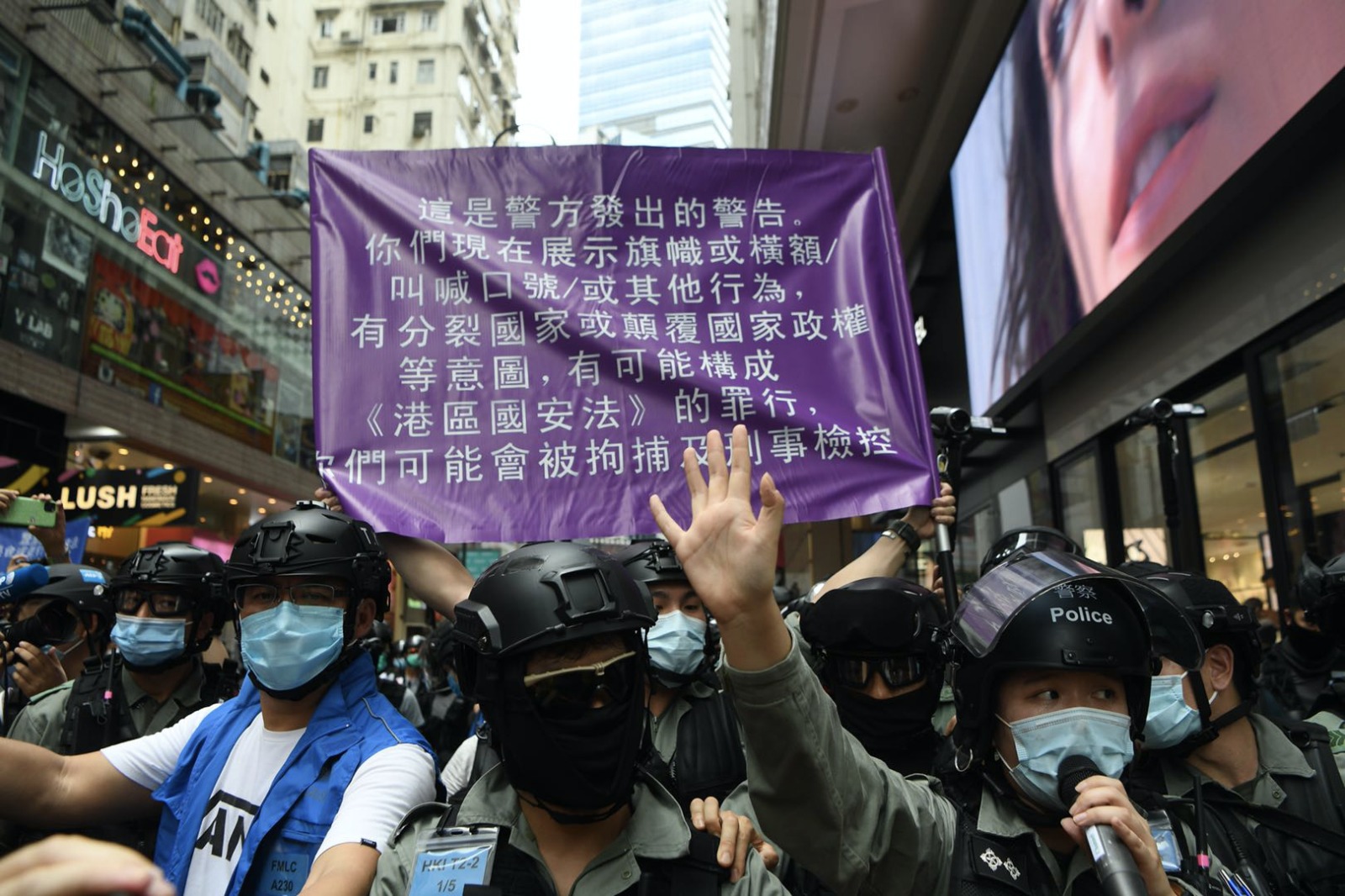 Hong Kong police hold up a purple flag, which warns the public that their actions may breach the national security law, on July 1, 2020. Photo via Facebook/Hong Kong Police