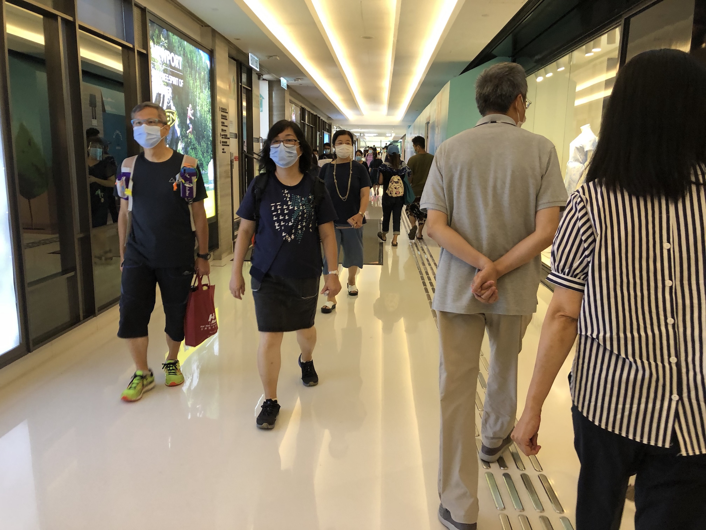 People walk through a corridor in New Town Plaza in Sha Tin on July 30, 2020.