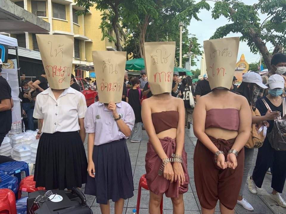 'Return the people's power, we are not slaves, we are free (Thai),' bags on protesters' heads read at today's ongoing rally at the Democracy Monument.