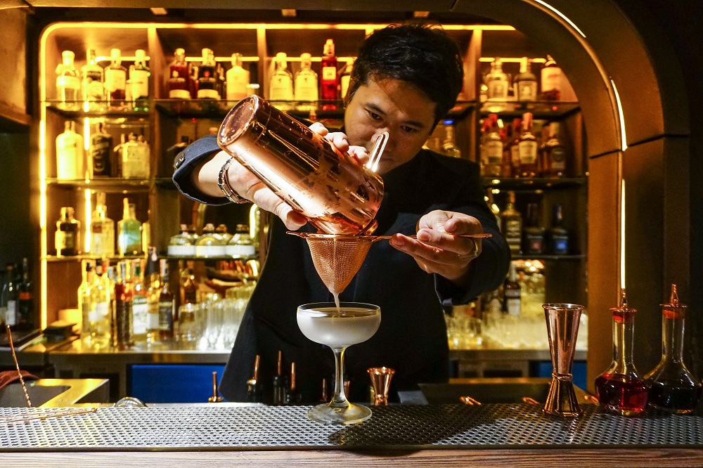 A bartender at Philtration pours a drink. Photo: Chayanit Itthipongmaetee / Coconuts Bangkok