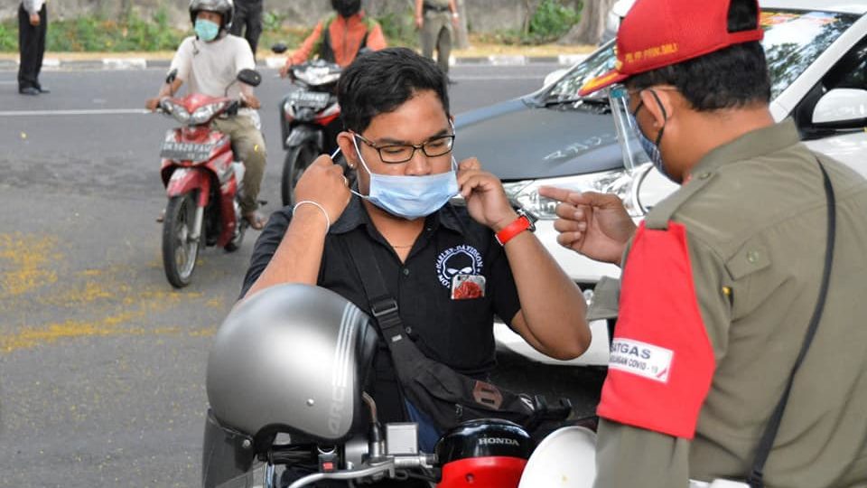 File photo of an officer enforcing the mandatory mask rule in Bali. Photo: Bali Provincial Government