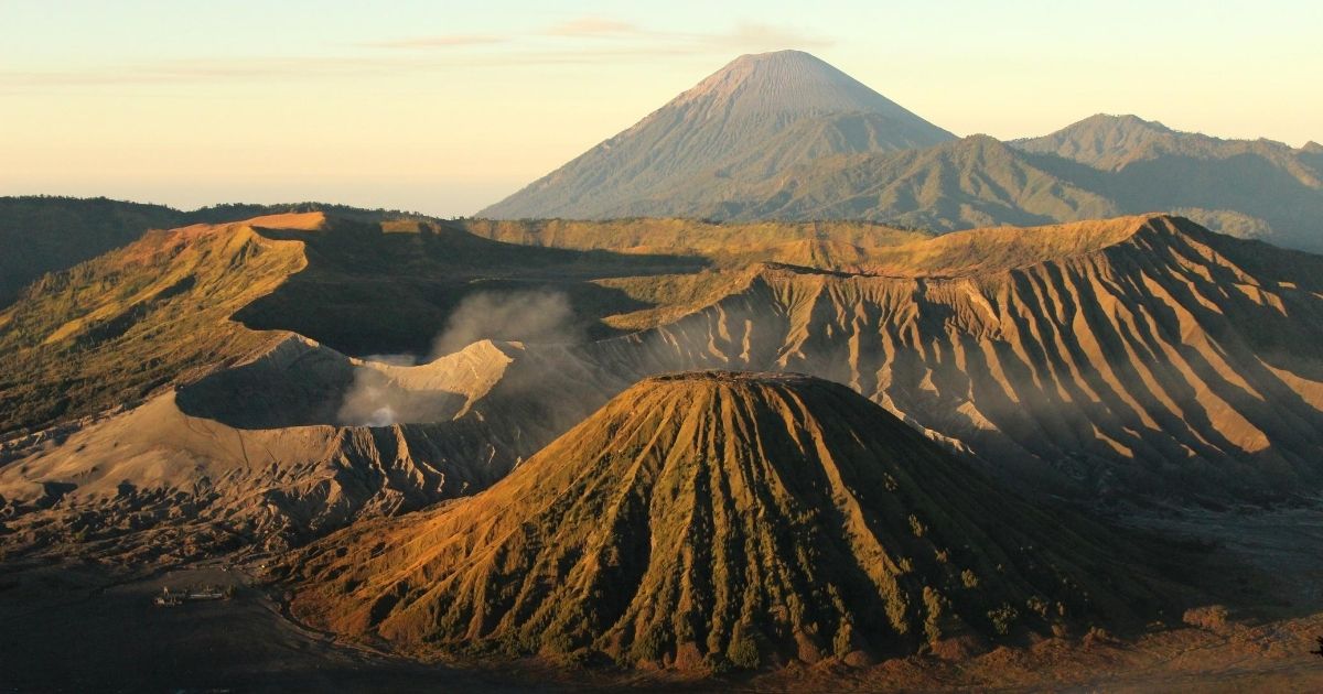 Mount Bromo (large crater, smoking) and Mount Batok with Mount Semeru in the background. Photo: Eveline Tania Mustika/Wikimedia Commons