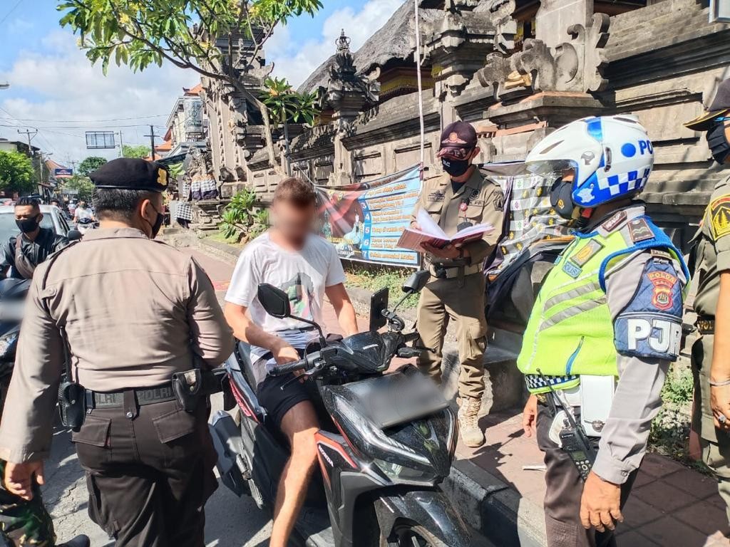 File photo of authorities stopping a foreigner without a mask in Jimbaran in September 2020. Photo: Satpol PP Badung