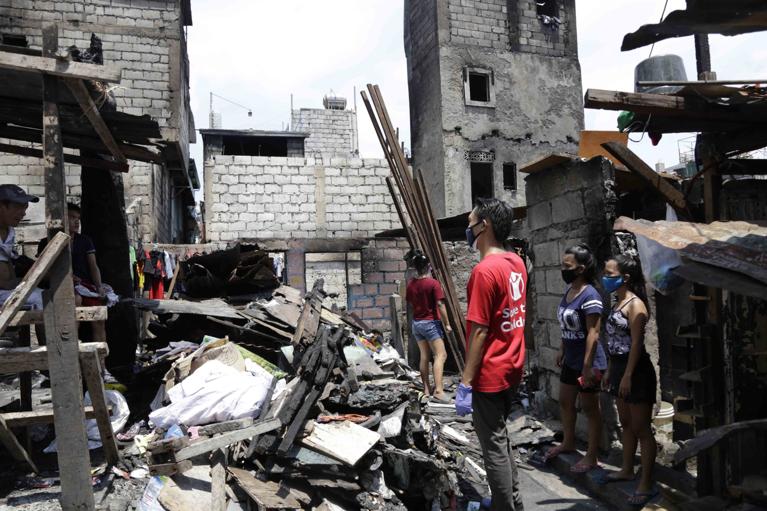 Save the Children staff inspecting homes damaged by a fire that occurred when Pasay City was under the enhanced community quarantine early this year. Photo by Save the Children