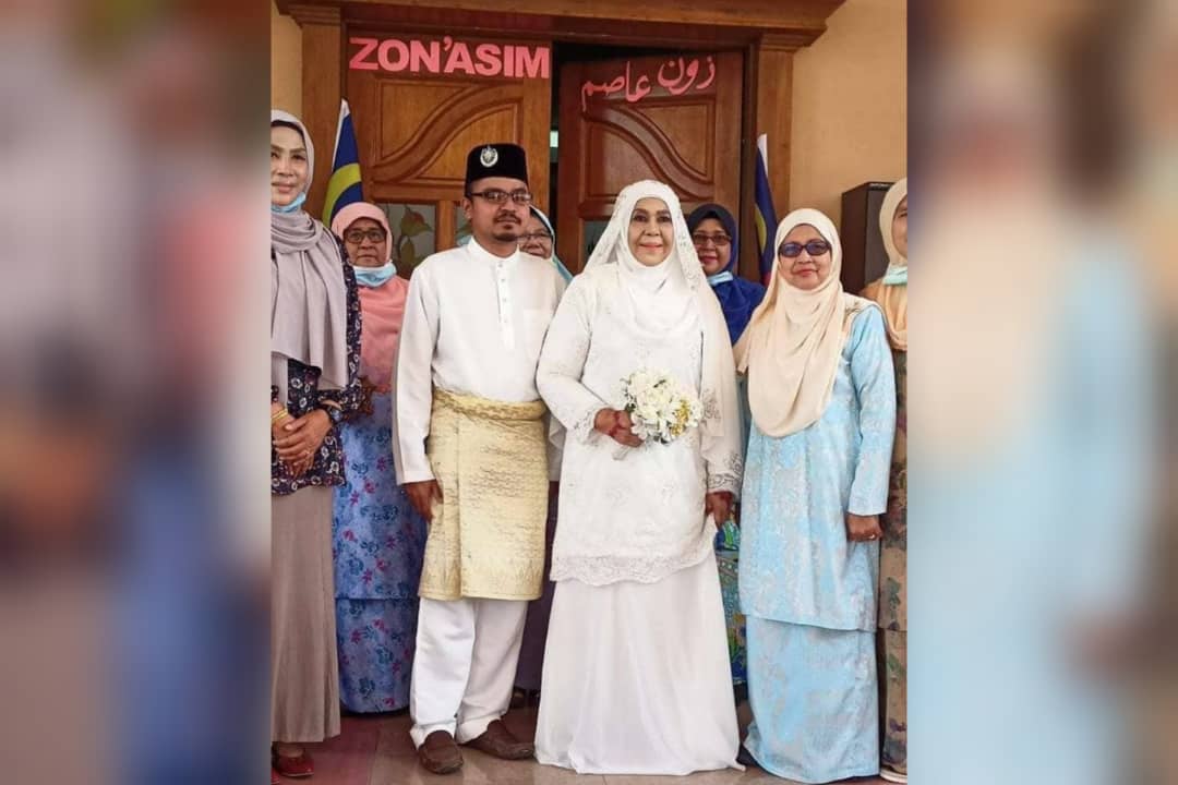 Zaleha Bujang and Muhammad Asyraf (middle, dressed in white) at their wedding ceremony surrounded by family members. Photo: Viral Informasi Malaysiaku /Facebook

