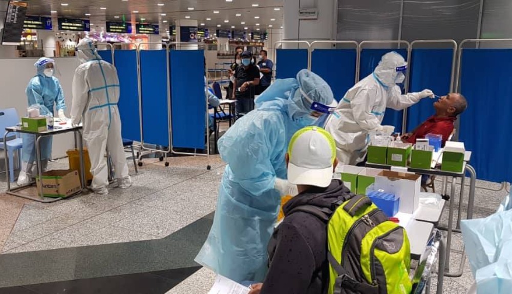 Medical staff giving COVID-19 swab tests to passengers at the Kuala Lumpur International Airport. Photo: Ministry of Health/Facebook