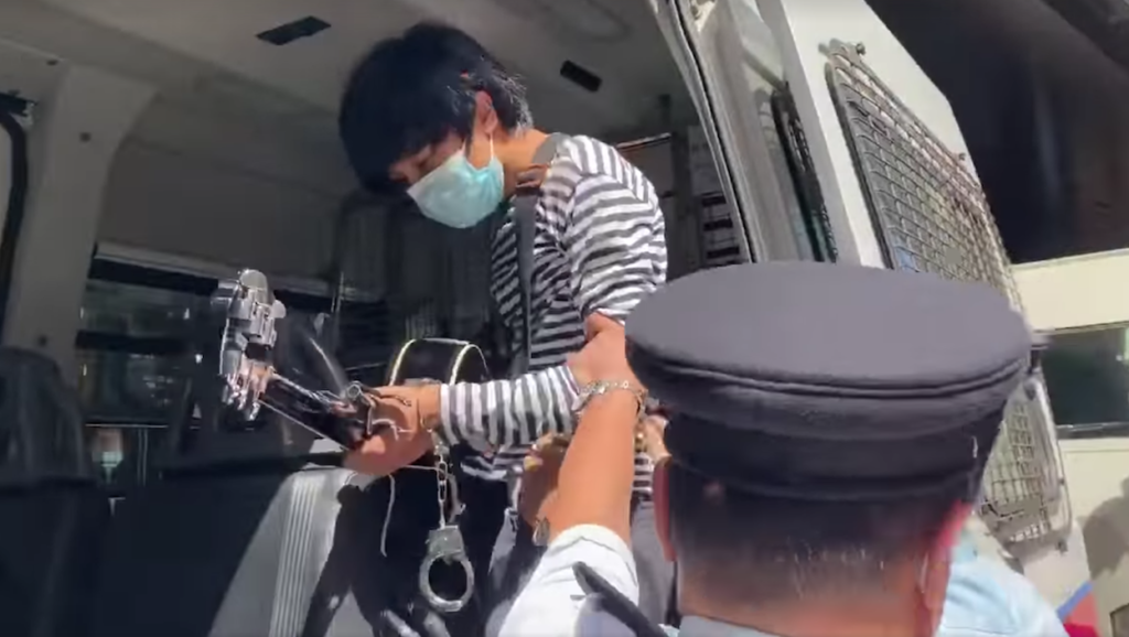 The toy handcuffs dangle off Ma's wrist as he gets into the police van. Screenshot via Facebook/Cheung Kai Yin