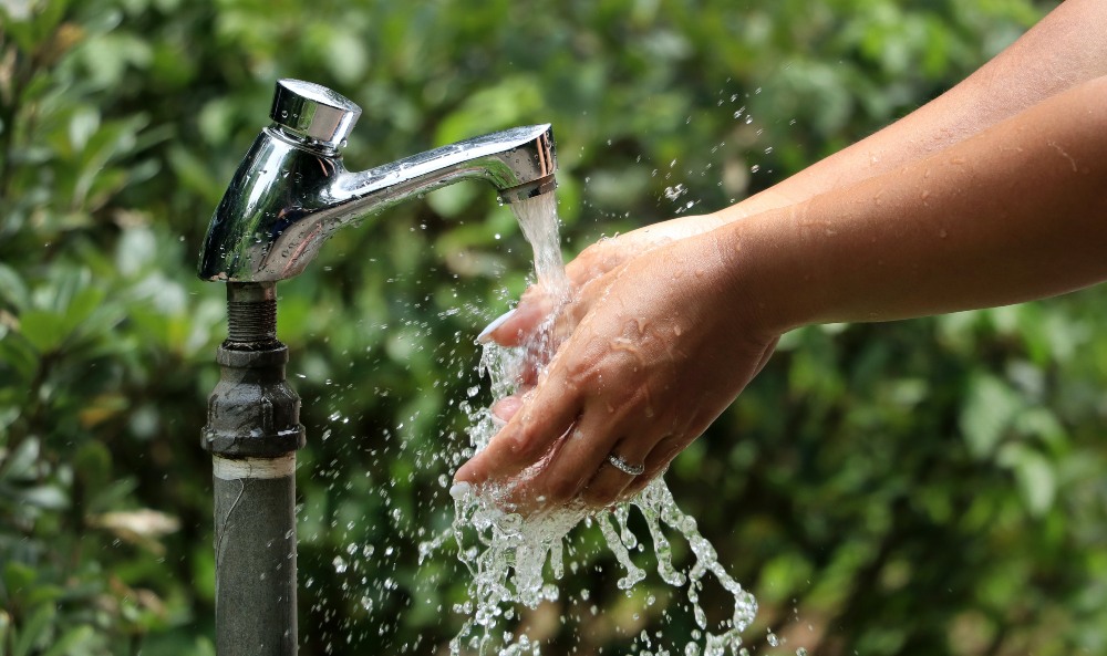 File photo of a person washing their hands by an outdoor tap. Photo: Macau Photo Agency
