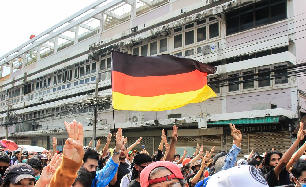 Protesters carry a German flag as they march Oct. 14 from the Democracy Monument to the Government House. Photo: Coconuts
