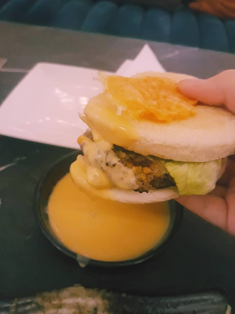 Dipping the burger in honey cheese sauce. Photo: Coconuts KL