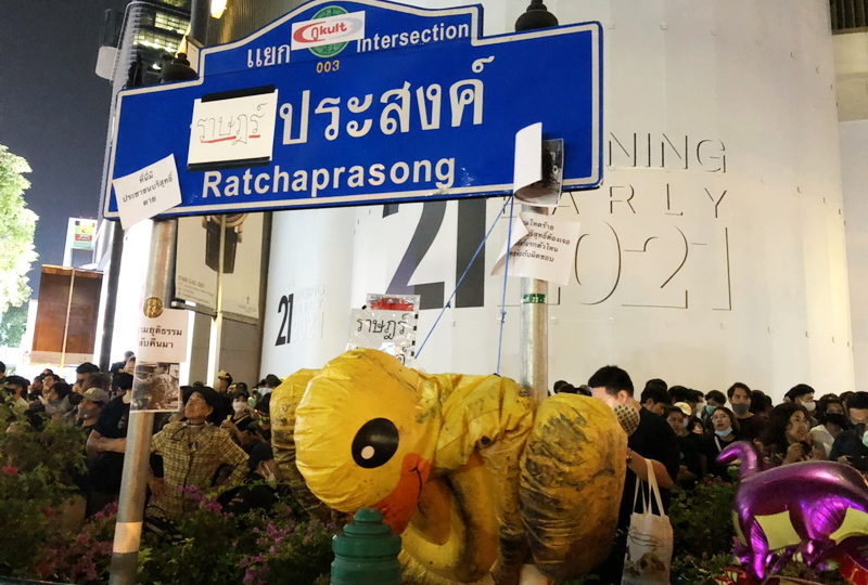 An Inflatable duck is displayed Wednesday evening at Bangkok’s Ratchaprasong intersection sign in honor of their use in defending against police water cannons. Photo: Coconuts 