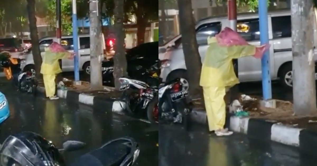 In the video, the woman in the yellow raincoat appears to be holding another raincoat on her head over a grey-white cat, who was enjoying its meal amid the pouring rain. Photo: Instagram/@kulinerdisolo