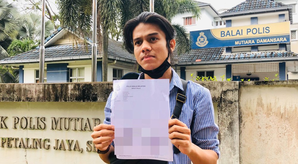 Da’i Syed holding up a copy of his police report outside the Mutiara Damansara police station. Photo: Da’i Syed/Twitter